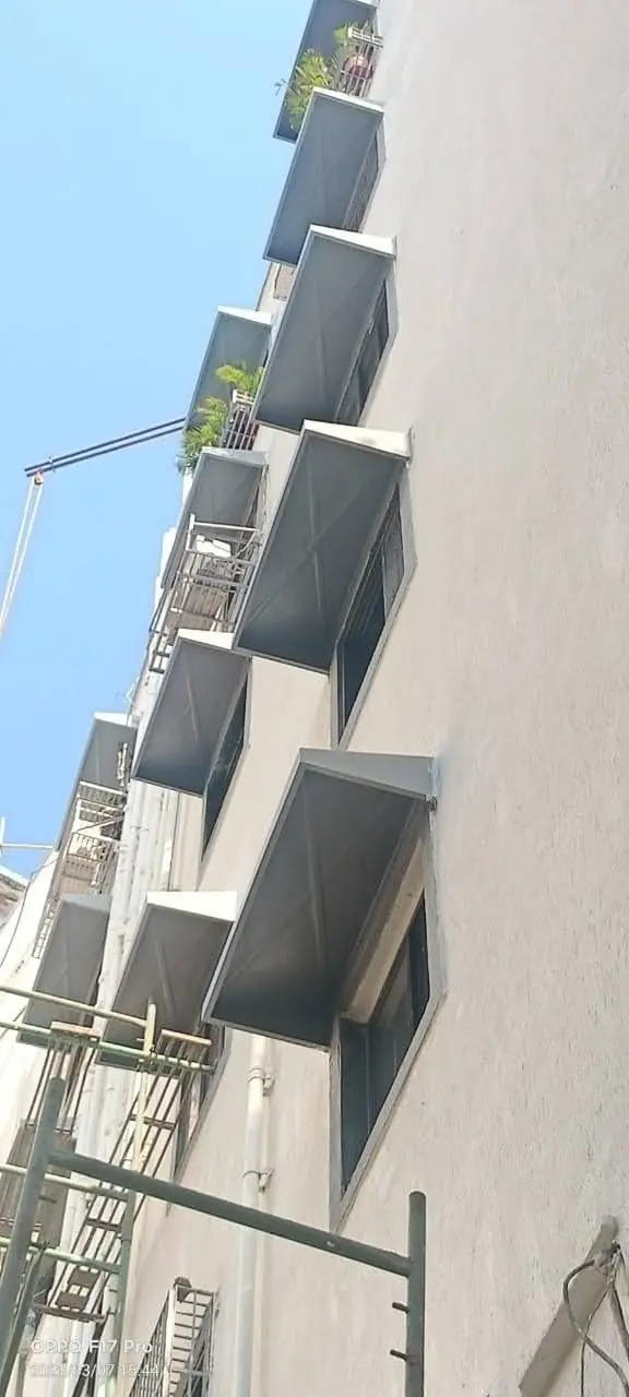 Grey FRP chajjas along a building