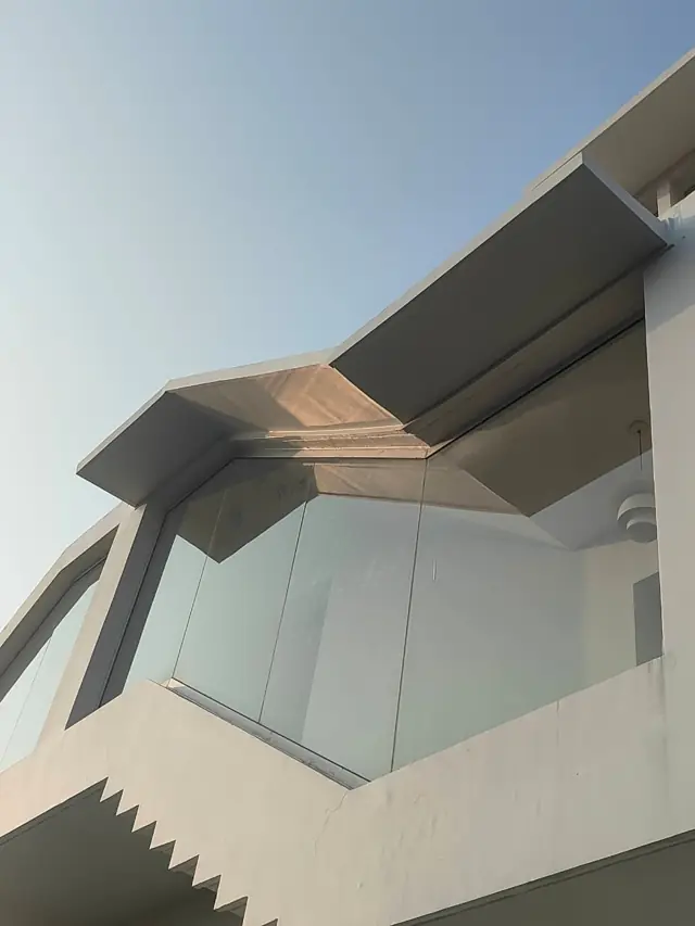 Modern angled FRP chajja over a glass window