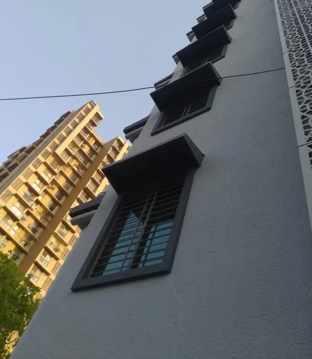 Dark FRP chajjas on a hospital building